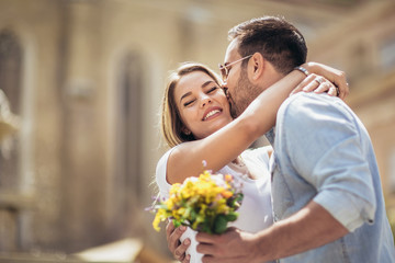 Picture of young man surprising woman with flowers