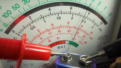 Testing the output voltage of a dry cell battery with an electrical multimeter. The meter reading showing that the battery is just in the meter's good range.