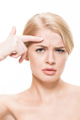 unhappy naked woman pointing at wrinkles on forehead and looking at camera isolated on white