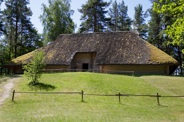 Fototapeta na wymiar Traditional old wooden house with reed roof in Latvia