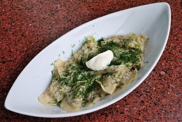 Russian dumplings (vareniki) with mushrooms and potatoes served with dill and sour cream in Moscow, Russia