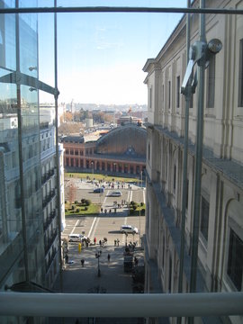 Vista de ciudad desde altura de ascensor con edificios hist&oacute;ricos en primer plano,  y estaci&oacute;n de tren hist&oacute;rica en segundo plano con fondo de horizonte de ciudad y cielo azul con nubes de invierno