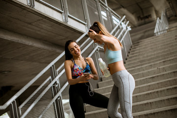 Fototapeta na wymiar Two young woman workout in urban environment