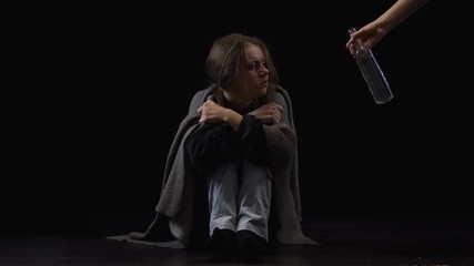 Alcohol addicted woman suffering withdrawal symptoms, rejecting hand with bottle