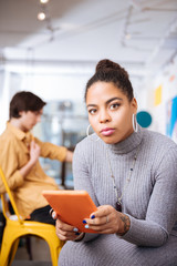 The young woman holding a tablet in the orange case