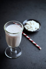 Glass of protein shake and glutamine. Nutrition for bodybuilding. Black stone background. Copy space.