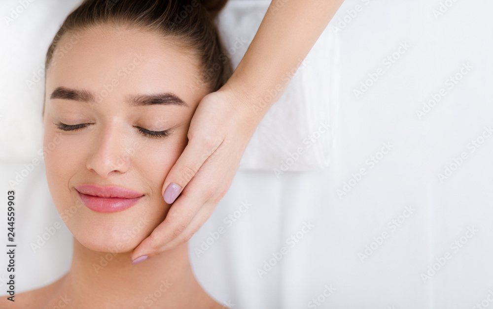 Wall mural facial massage. woman getting professional face treatment