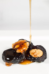 Healthy Food- Dried Plums Filled With Walnuts And Honey Flowing Down On Plums