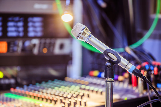 Microphone in the recording studio, equipment in the blurry background