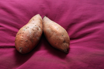 Słodkie ziemniaki . Warzywa na różowo purpurowym tle. - obrazy, fototapety, plakaty