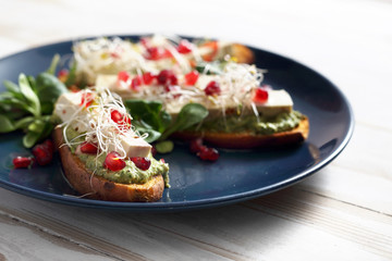 Warzywna potrawa obiadowa. Pieczone bataty z zielonym pesto, tofu i kiełkami.