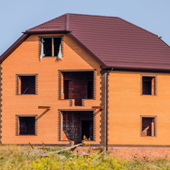 Obraz premium The house with plastic windows and a roof of corrugated sheet. R