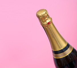 Bottle of champagne isolated on plain pink background