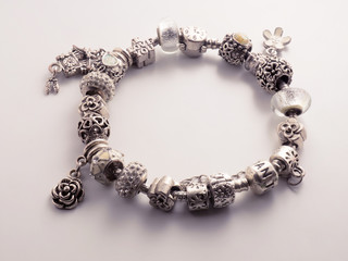 Silver color bracelet on a white background with a shadow