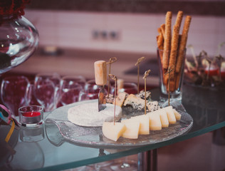 sliced ​​from different types of cheese: brie, gorgonzola, cheddar.Grissini.Horizontal composition
