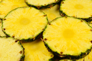 Pineapple juicy yellow slices background. Top view.