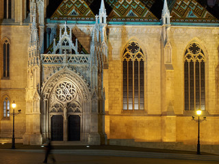 Night shot of an illuminated side portal of Matthias Church in Budapest, Hungary - obrazy, fototapety, plakaty