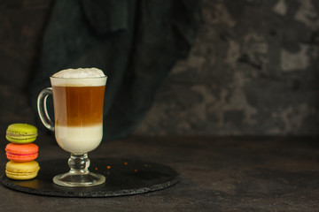 Latte in a transparent cup, macaroon cake (coffee dessert). Top Food background