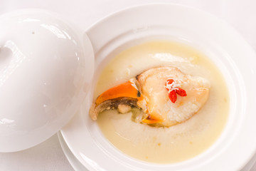 Steamed crab claw with minced ginger and rice wine served in white porcelain