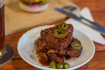 korean fried chicken wings with savoury sweet sauce and pickled green chilli