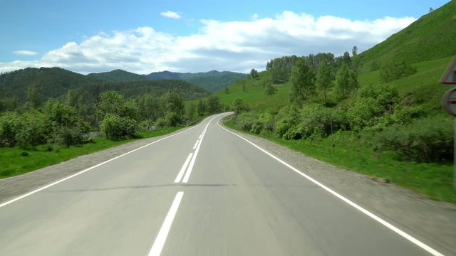 The highway in the mountain area. Movement of the camera. 4K. Sky and clouds.