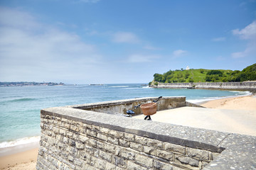 Bicycle with a basket parked on a stone embankment of Saint Jean de Luz against the background...