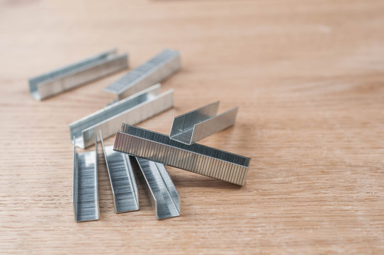 metal staples on wooden background