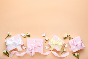 Gift boxes with rose flowers and white hearts on beige background
