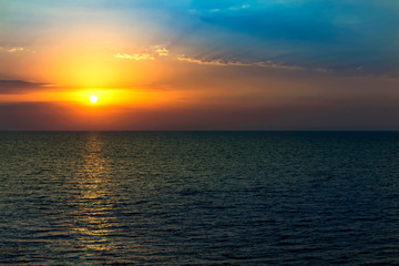 Beautiful sunset on seaside at exotic travel destination on ocean shore.Sparkling water surface under dusk lighting in summer evening.