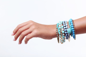 Female hand with bracelets on white background