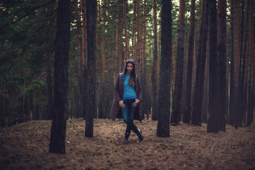Art portrait of woman posing in the autumn dark forest