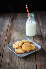 Butter cookies with Cashew nut and chocolateship on plate served with bottle of milk. Sweet dessert and healthy beverage. Favorite dessert for children.