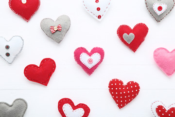 Colorful fabric hearts on white wooden table