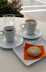 Two cups of coffee with milk on a table.