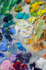 Fototapeta premium Artists acrylic paint palette close up semi abstract full frame background. Outdoors 'en plein air' paint palette on greaseproof paper in sunshine.