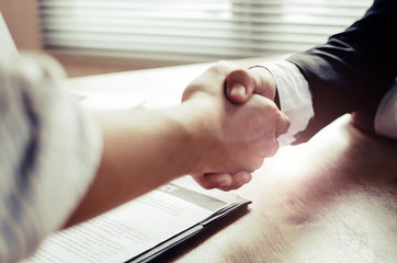 close up hand of two business people shaking hands after successful job interview in modern meeting room at office, home loan contract, partnership, teamwork and business contract concept - Powered by Adobe