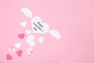 Inscription Happy Valentine Day with paper hearts on pink background
