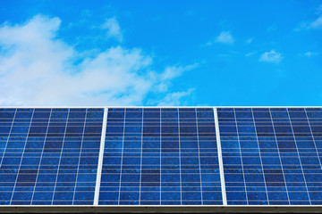 Obraz premium blue solar panels (solar cell) with blue cloud sky background in solar farm.