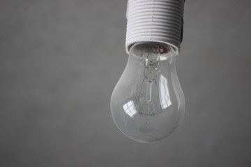incandescent bulb in the cartridge against a gray concrete wall. energy saving, environmental care. economical use of electricity.