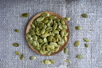 Pumpkin seeds in wooden plate  Burlap background Healthy organic food