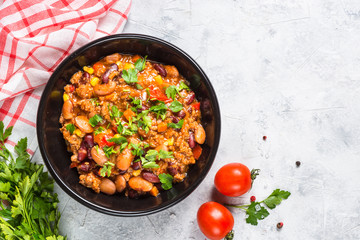 Chili con carne from meat and vegetables on stone table top view.