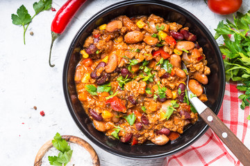 Chili con carne from meat and vegetables on stone table top view.