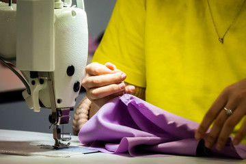 Clothing industry. Sewing machine. Atelier clothing. A woman works at the sewing machine. Tailoring. Training tailoring.