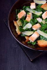 Salad with chicken, Parmesan cheese, crispy croutons and kale in a bowl