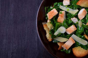 Salad with chicken, Parmesan cheese, crispy croutons and kale in a bowl