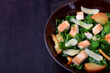 Salad with chicken, Parmesan cheese, crispy croutons and kale in a bowl