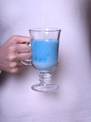 Blue tea Anchan with milk in an Irish glass in female hand