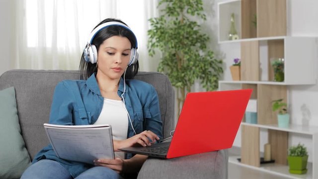 Serious student e-learning comparing notes online in a laptop at home