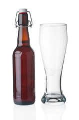 Beer bottle and empty glass on white background