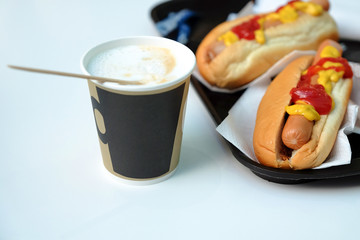 Simple hot dog sandwich breakfast with mustard ketchup and coffee.